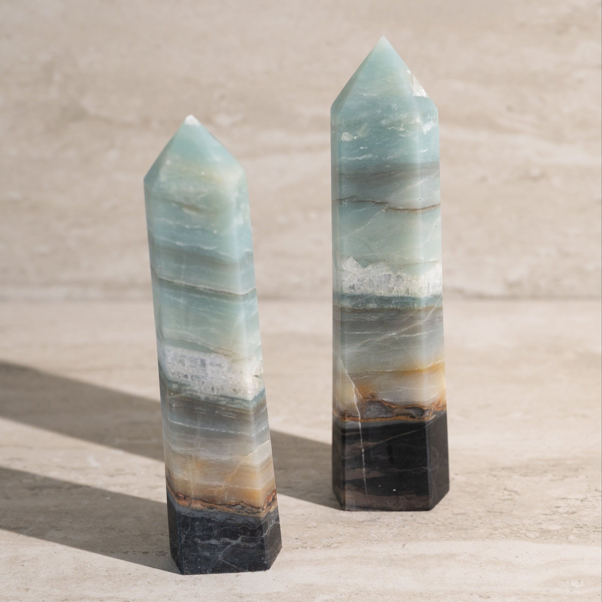 Two crystal towers on a neutral background