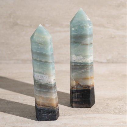Two crystal towers on a neutral background
