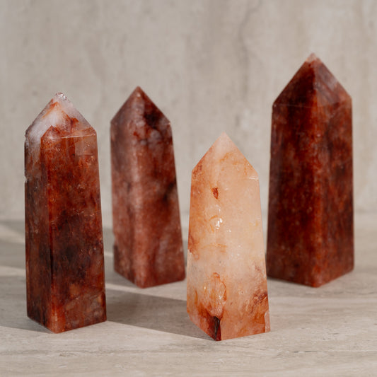 Four crystal towers on a wooden surface with a neutral background