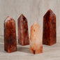 Four crystal towers on a wooden surface with a neutral background