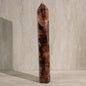 Tall, brown crystal tower on a neutral background