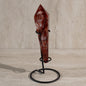 Red crystal on a black stand against a neutral background