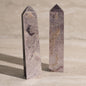 Two polished stone obelisks on a neutral background