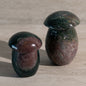 Two stone mushrooms on a beige surface