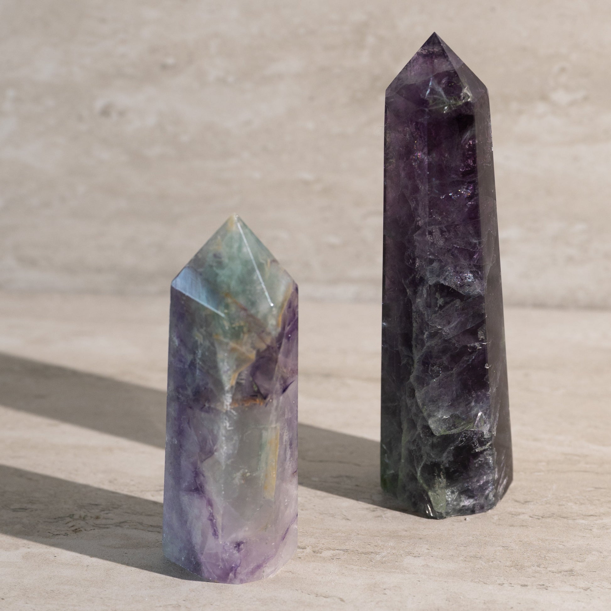 Two crystal points on a light wooden surface