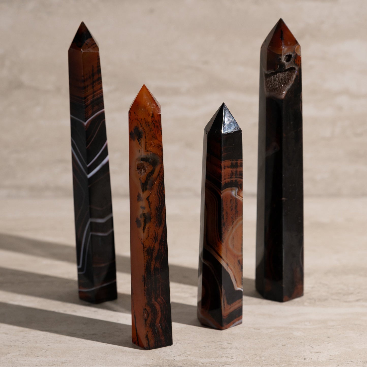 Four polished crystal obelisks on a wooden surface