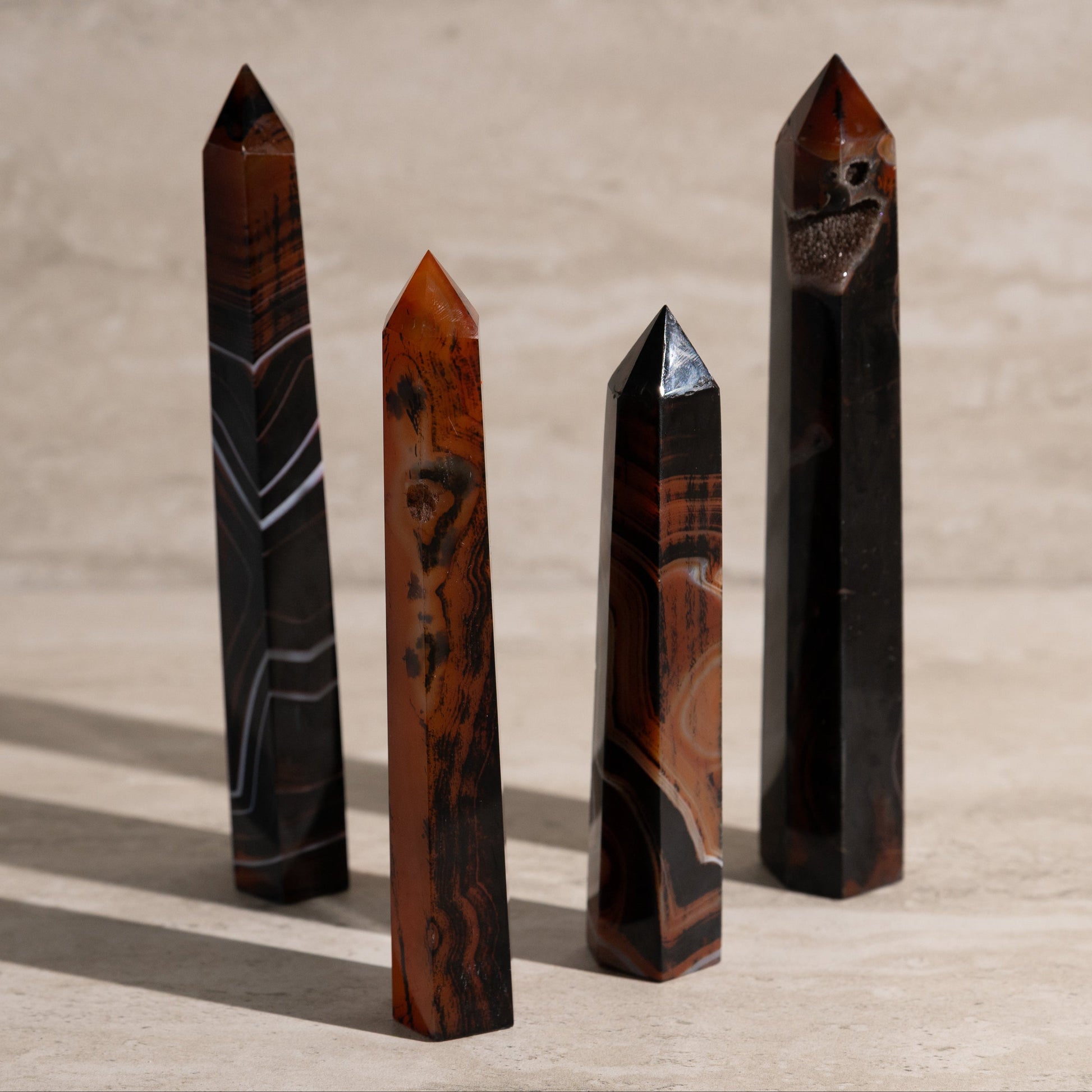 Four polished crystal obelisks on a wooden surface