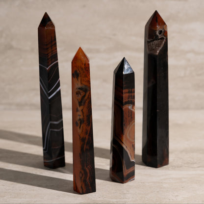 Four polished crystal obelisks on a wooden surface