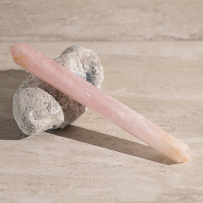 Pink crystal on a stone with a neutral background