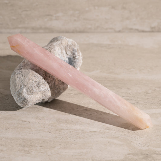 Pink crystal on a stone with a neutral background